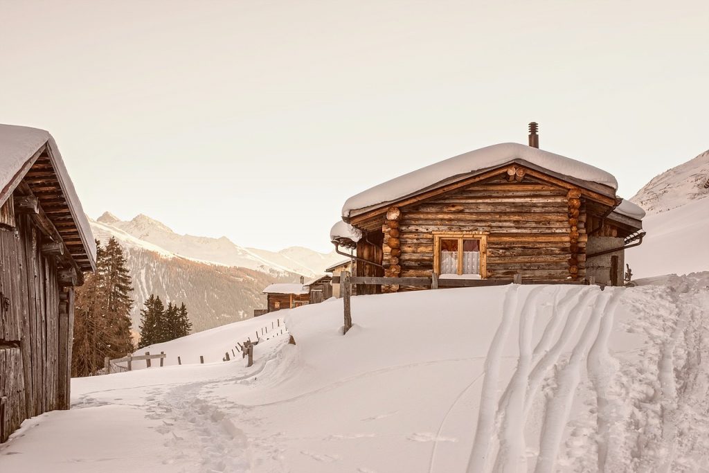 chalet de montagne en bois recouvert de neige